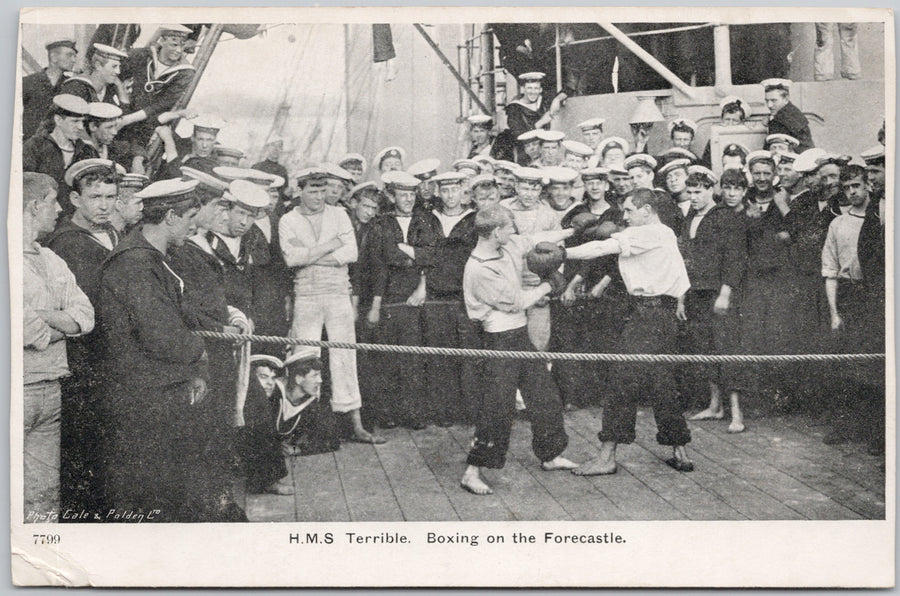 Boxing match on a ship with sailors watching.