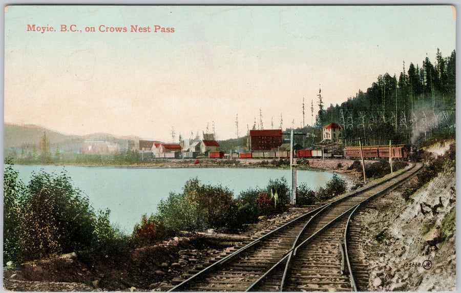 Vintage image of Moyie BC with train tracks and lakeside town on Crowsnest Pass – Dee’s Postcards